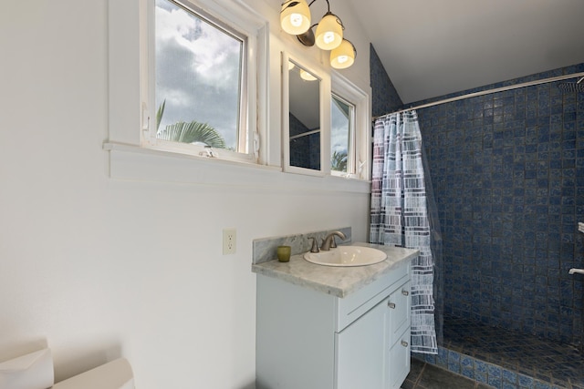 bathroom featuring tiled shower and vanity