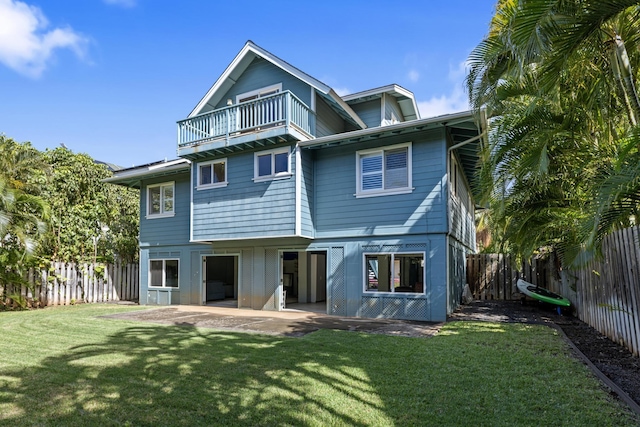 rear view of property featuring a fenced backyard, a patio area, a lawn, and a balcony