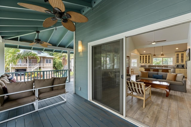 wooden terrace with an outdoor hangout area and a ceiling fan