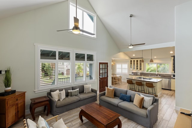 living area with baseboards, ceiling fan, recessed lighting, light wood-style floors, and high vaulted ceiling