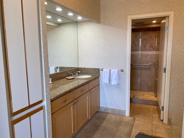 bathroom featuring tile patterned floors, vanity, and a shower with door