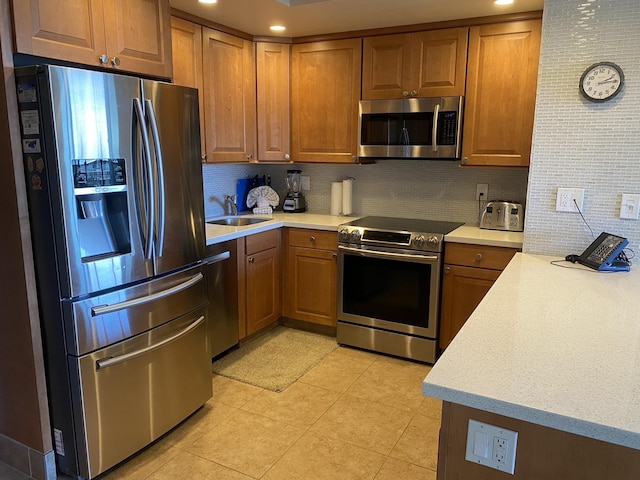 kitchen with tasteful backsplash, stainless steel appliances, sink, and light tile patterned floors