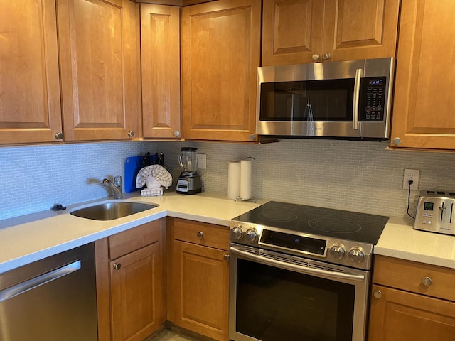 kitchen featuring appliances with stainless steel finishes, sink, and decorative backsplash