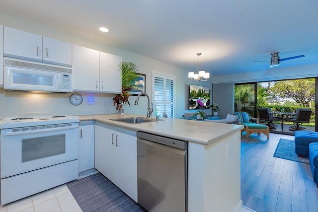 kitchen featuring sink, hanging light fixtures, kitchen peninsula, white appliances, and white cabinets