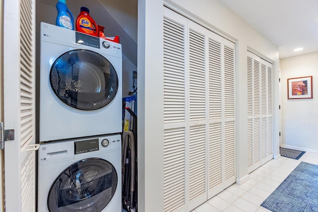 laundry area featuring stacked washer and dryer and light tile patterned floors