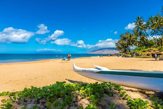 surrounding community featuring a water view and a beach view