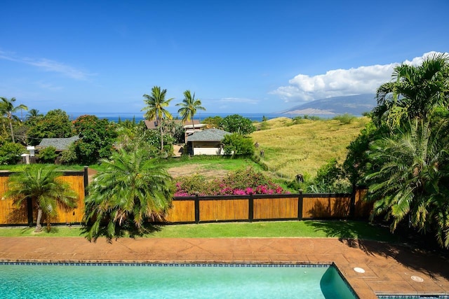 view of pool with a mountain view and a yard