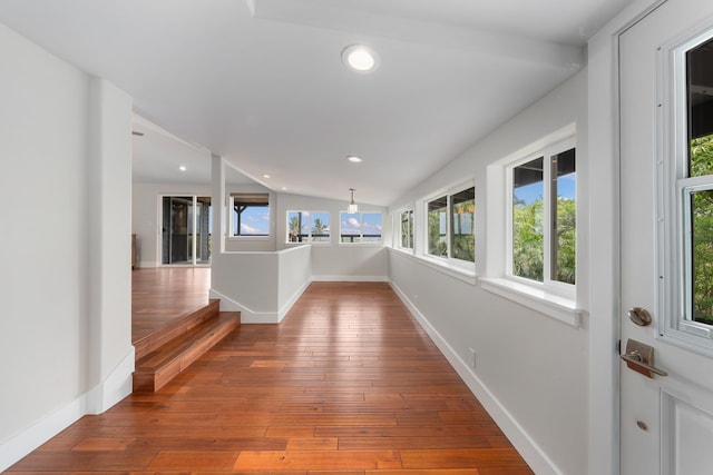 hallway featuring hardwood / wood-style flooring and lofted ceiling