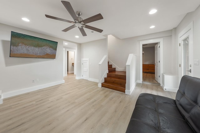 living room featuring ceiling fan and light wood-type flooring