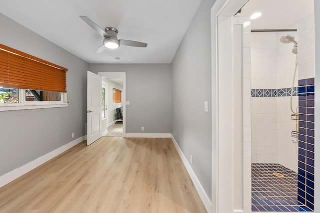 interior space with light wood-type flooring, ceiling fan, and connected bathroom