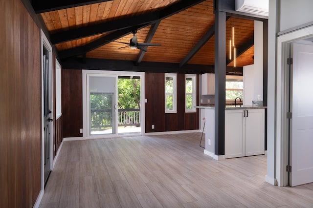 unfurnished living room with wood ceiling, lofted ceiling with beams, ceiling fan, and light hardwood / wood-style floors