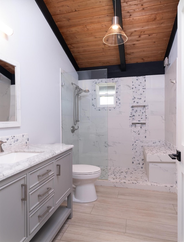 bathroom featuring a tile shower, wood-type flooring, toilet, vanity, and wood ceiling