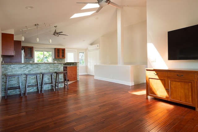 kitchen with a skylight, decorative backsplash, high vaulted ceiling, and dark hardwood / wood-style floors