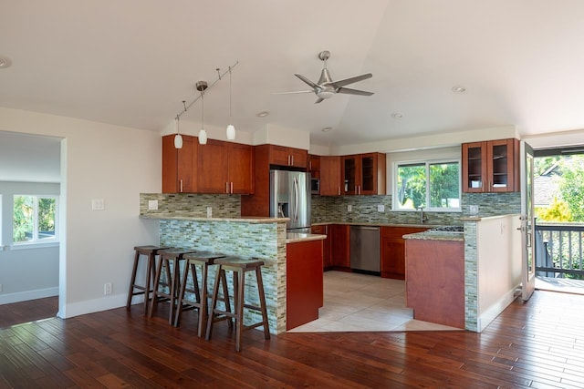 kitchen with tasteful backsplash, light hardwood / wood-style flooring, lofted ceiling, and appliances with stainless steel finishes