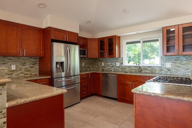 kitchen with sink, light stone counters, decorative backsplash, light tile patterned floors, and appliances with stainless steel finishes