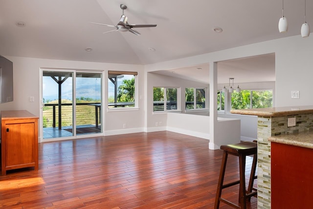 living room featuring ceiling fan, dark hardwood / wood-style floors, and vaulted ceiling