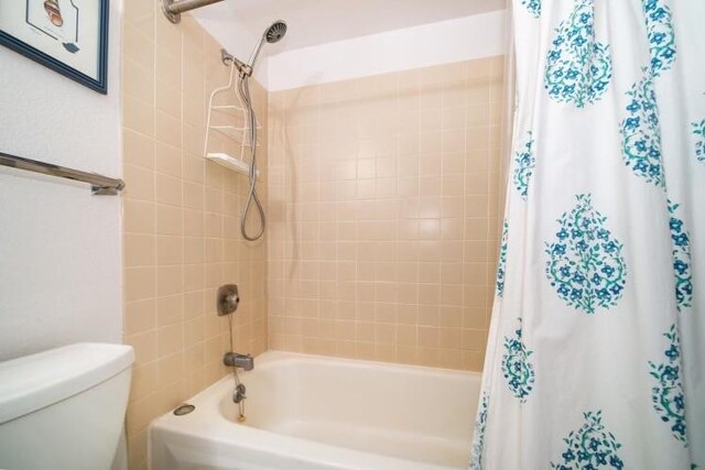 bathroom with toilet and shower / bath combo