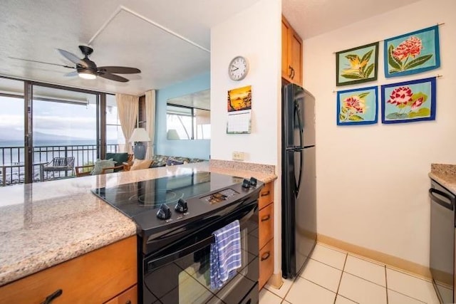 190 Hauoli St Unit 220, Wailuku, HI 96793 - kitchen featuring a ceiling fan, brown cabinets, light tile patterned floors, black appliances, and a water view