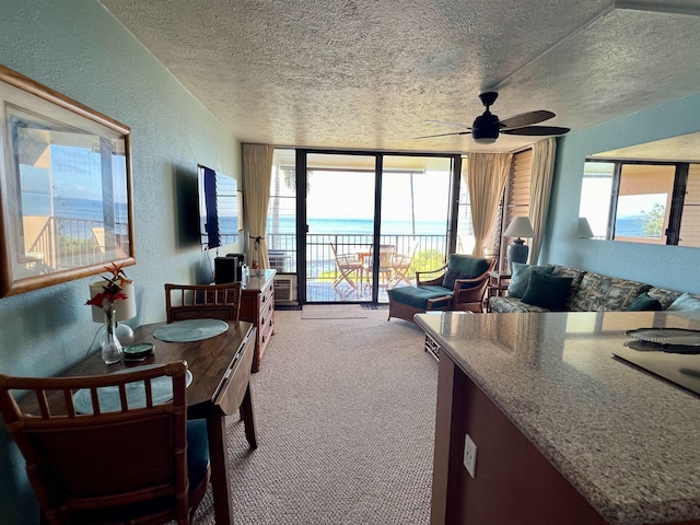 190 Hauoli St Unit 220, Wailuku, HI 96793 - carpeted dining area with ceiling fan, a textured wall, floor to ceiling windows, and a textured ceiling