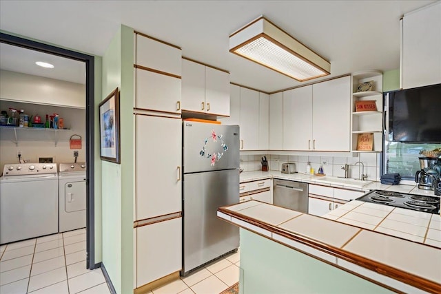 2661 Kekaa Dr Unit L-202, Lahaina, HI 96761 - kitchen with stainless steel appliances, washing machine and dryer, tile counters, open shelves, and a sink