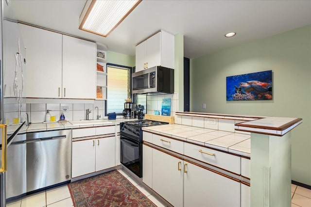 2661 Kekaa Dr Unit L-202, Lahaina, HI 96761 - kitchen with stainless steel appliances, a sink, open shelves, tile countertops, and decorative backsplash
