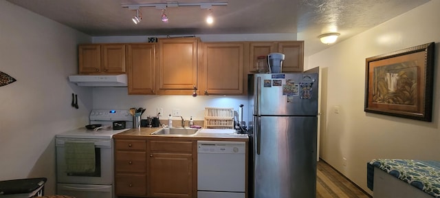 kitchen with a textured ceiling, sink, white appliances, and rail lighting