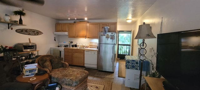 kitchen featuring white appliances, light brown cabinetry, light tile patterned floors, and sink