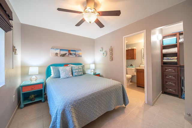 bedroom with ceiling fan, light tile patterned floors, and ensuite bathroom