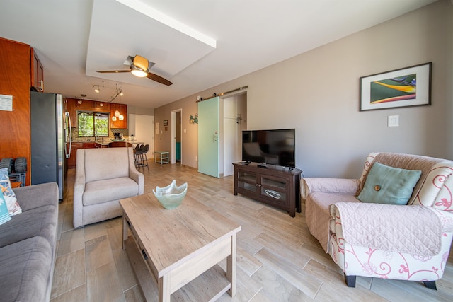 living room with light hardwood / wood-style floors and ceiling fan