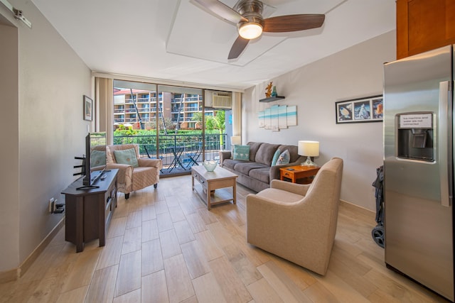 living room featuring a wall mounted air conditioner, a wall of windows, light hardwood / wood-style flooring, and ceiling fan