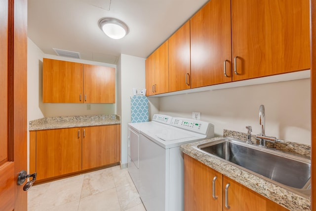 clothes washing area featuring washer and dryer, light tile patterned floors, sink, and cabinets