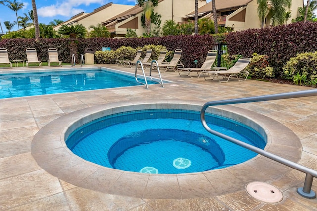 view of swimming pool featuring a patio area and a hot tub