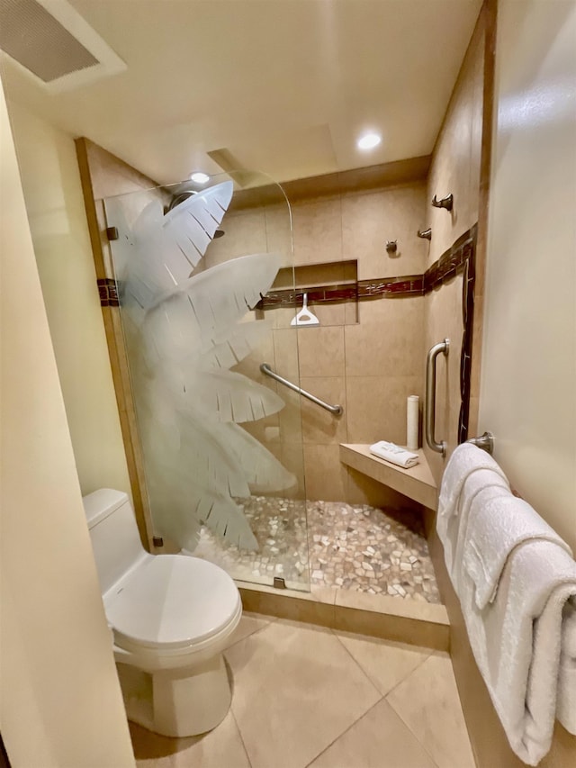 bathroom with a shower with shower door, tile patterned floors, and toilet