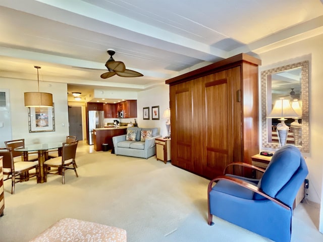 living room featuring ceiling fan, beam ceiling, and light carpet