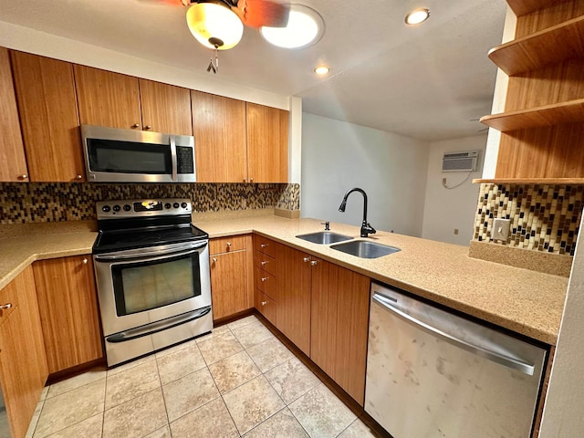 kitchen featuring kitchen peninsula, tasteful backsplash, appliances with stainless steel finishes, light tile patterned flooring, and sink