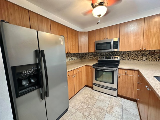 kitchen with ceiling fan, stainless steel appliances, decorative backsplash, and light tile patterned flooring