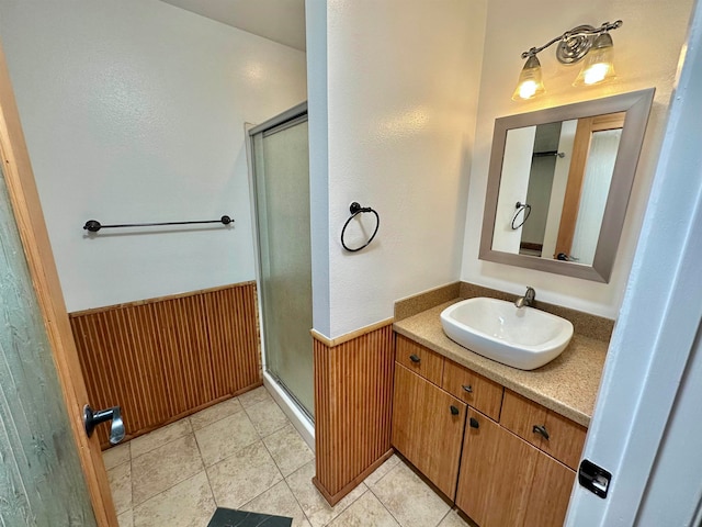 bathroom featuring vanity, tile patterned flooring, wooden walls, and a shower with door