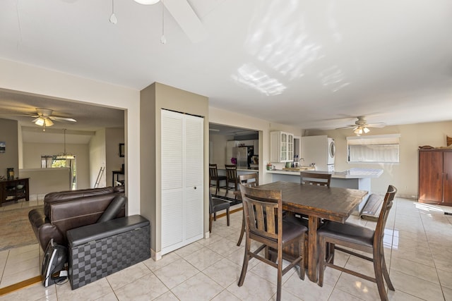 dining space with a ceiling fan and light tile patterned floors