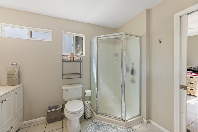 full bath featuring baseboards, a shower stall, toilet, and tile patterned floors