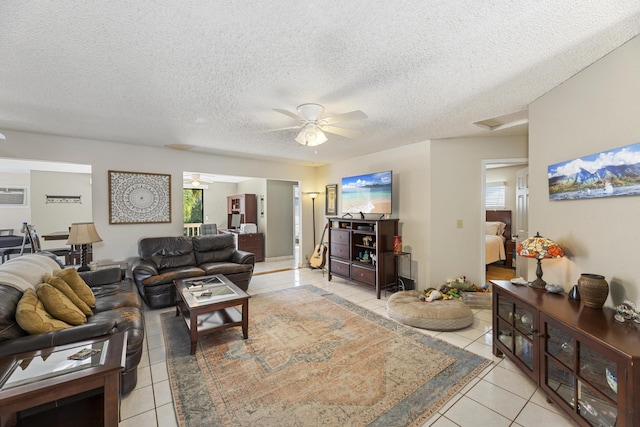 living room featuring a wall unit AC, ceiling fan, a textured ceiling, and light tile patterned floors