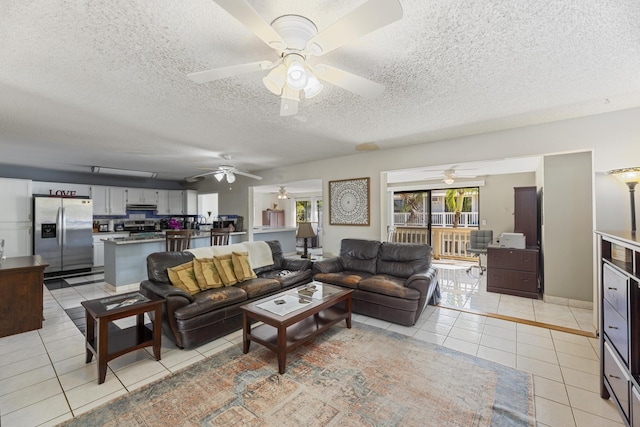 living area featuring a textured ceiling and light tile patterned floors