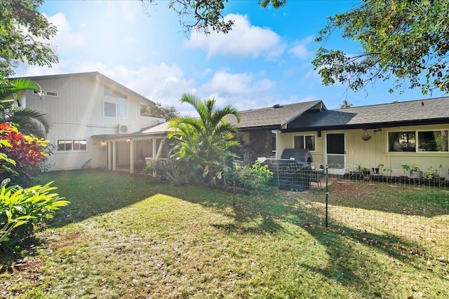 rear view of house featuring a yard and a sunroom