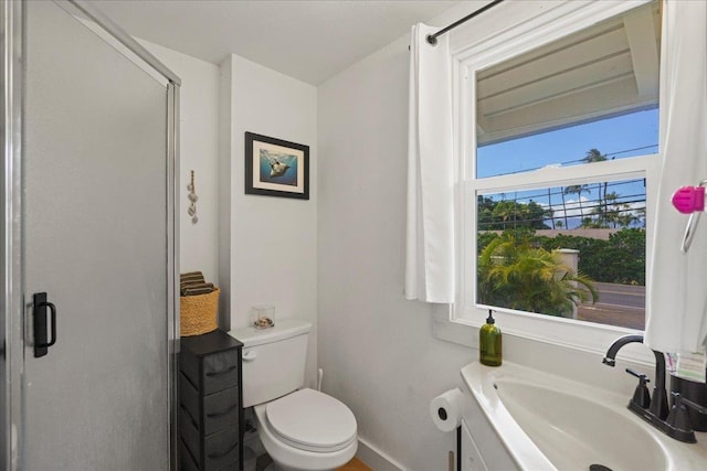 full bathroom featuring a shower stall, toilet, baseboards, and vanity