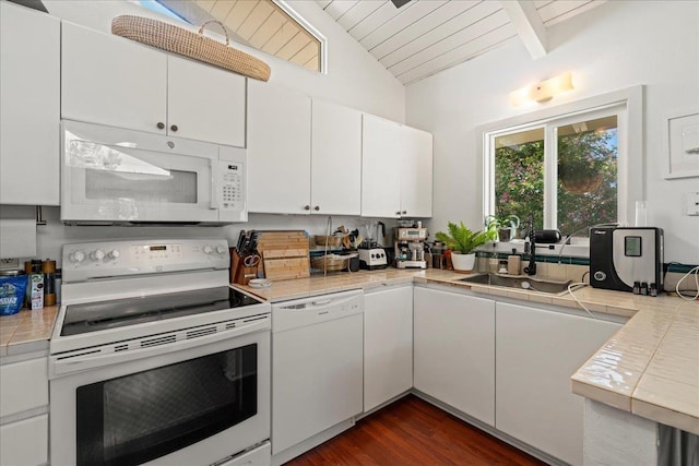 kitchen with white appliances, tile counters, white cabinets, dark wood finished floors, and a sink