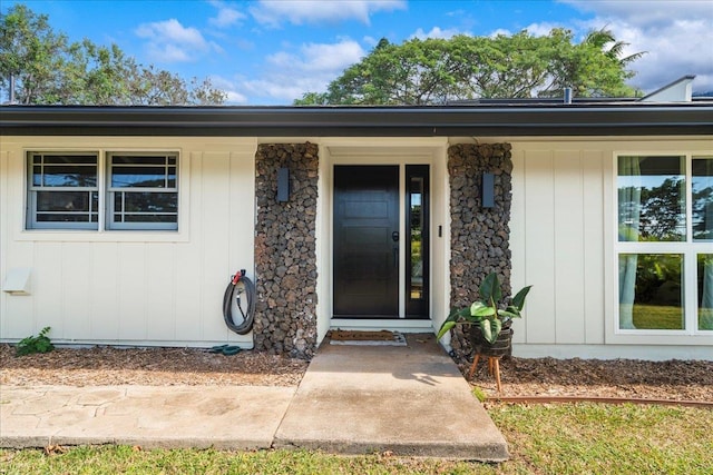 entrance to property featuring stone siding and covered porch