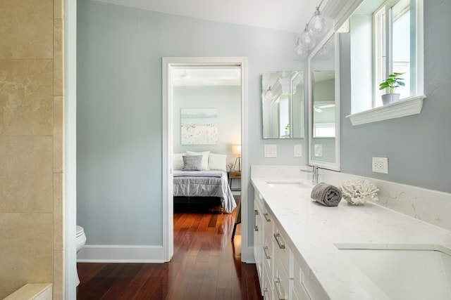 bathroom with hardwood / wood-style flooring, a wealth of natural light, toilet, and a sink