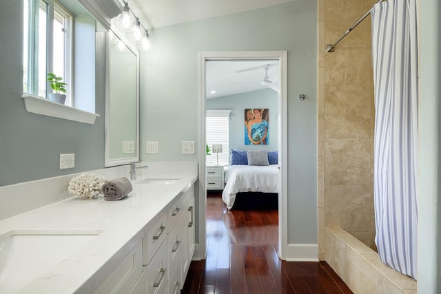 ensuite bathroom with wood finished floors, a sink, double vanity, and ensuite bathroom