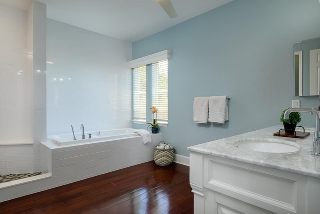 bathroom featuring a bath, baseboards, vanity, and hardwood / wood-style floors