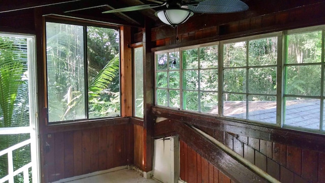 unfurnished sunroom featuring ceiling fan