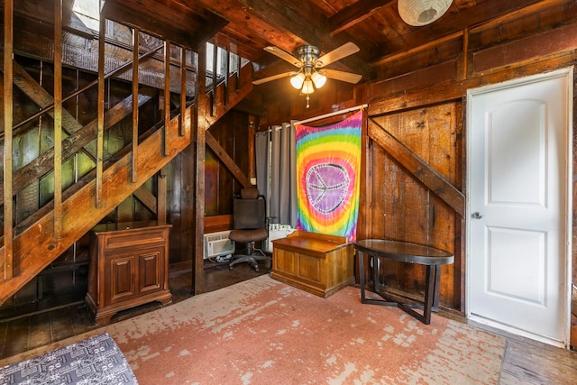 unfurnished living room with beam ceiling, ceiling fan, an AC wall unit, wood walls, and wood ceiling